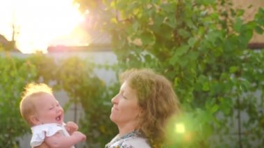 Mutlu anne ile kız bebek. Bebek yüz gülümseyen anneler el sallıyor. Objektif yansıma.