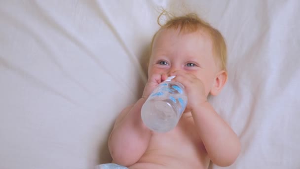 Baby girl drinking water from bottle. Nutrition for babies. — Stock Video