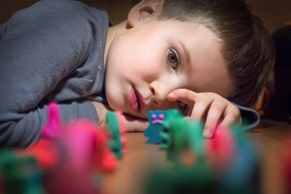 Jongen en speelgoed. Kleurrijke speelgoed gemaakt van plasticine. — Stockfoto