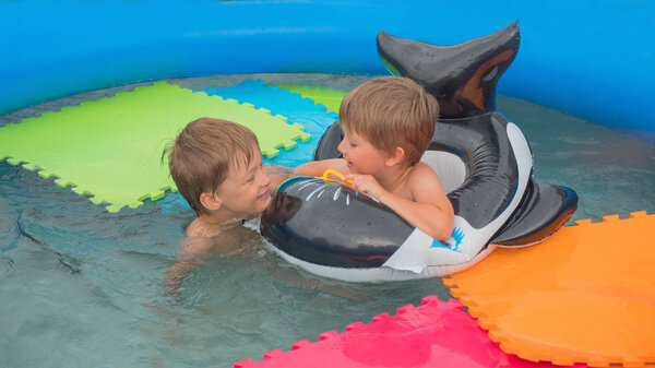 Children and nature. Summer time. Traveling concept. Vacation. Travel with children. Water games. Happy childhood concept. Cheerful children playing in water. Water pool on front, back yard.