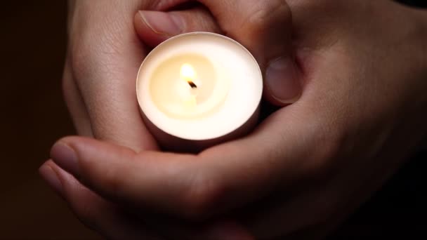 Kerze Der Hand Nahaufnahme Hintergrund Des Kerzenlichts Frauenhänden Gnadengrund Trauerbegriff — Stockvideo