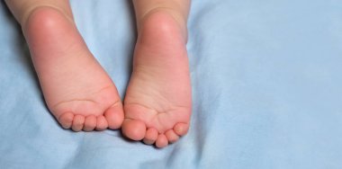 Bebeğin tatlı küçük barefeet. Çocuk ayak. Yatakta barefeet. Çocuğun ayak yatakta. Bebek, barefeet üzerinde odak ile kaynıyor. Topuk ve ayak parmakları yatakta. Topuklar ve ayaklar. Kopya alanı.