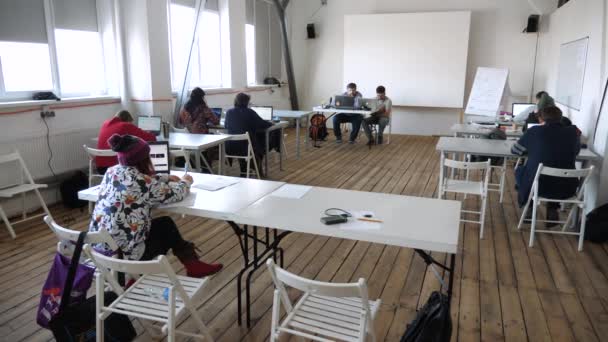 Professor a fazer um exame. Sala de aula moderna. Leccionando fundo do corredor. Escola de mídia, conceito de escola privada. Processo de palestras. Estudantes a fazer exames, seminários. Fórum. Escola de animação Oficina ideia estúdio — Vídeo de Stock