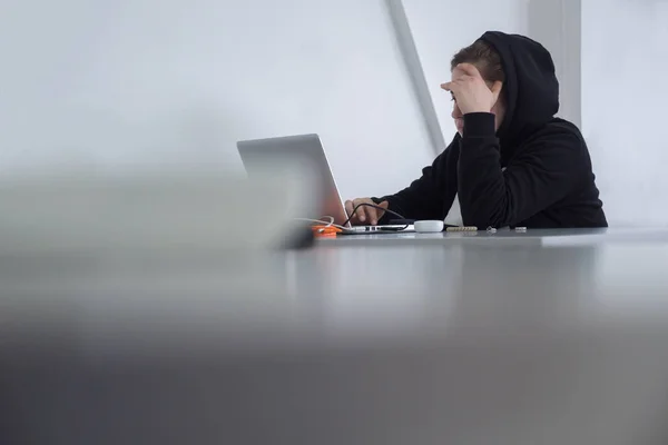 Mujer vestida de negro con portátil. Mujer con capucha sentada a la mesa. Estudiante sentado con laptop. Estudiante en Hijab. Estudiante musulmán con cuaderno. Mujer trabajadora sobre fondo blanco idea de seguridad cibernética —  Fotos de Stock