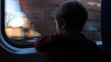 Tren ile seyahat. Tren çocuğa. Şirin 5 yaşında çocuk trende pencereden bakıyor. Çocuklarla seyahat. Çocuk pencereden bakıyor.