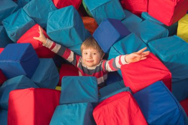 Çocuk doğum günü için oyun çocuk odanın kuru havuzda yumuşak küpleri ile oynarken. Eğlence Merkezi. kapalı oyun alanında trambolin çukura sünger. Çocuklar için eğlence