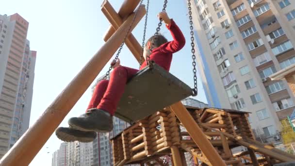 Pojke svänga på trä swing. Trä lekplats med barn gungande. Happy Childhood koncept. Joyful tonåring svänger på en swing. — Stockvideo