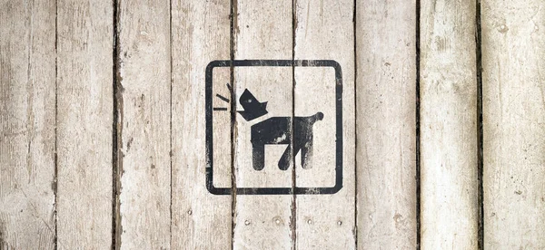 Barking dog silhouette in black color. Barking dog sign on a white wooden background. Guard dog inside icon. Dog Barking icon. Button image on wooden background. Copy space. Part of a series