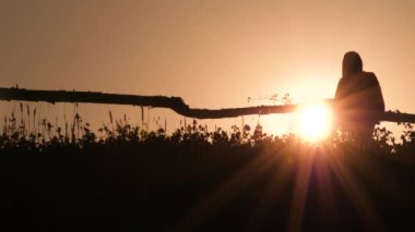 İşçi gün batımı arka plan arka ışık üzerinde sıkı çalışmadan sonra eve gidiyor. Tarım kavramı. Yeşil turizm arka planı. Yaz tatili. Eko yaşam.