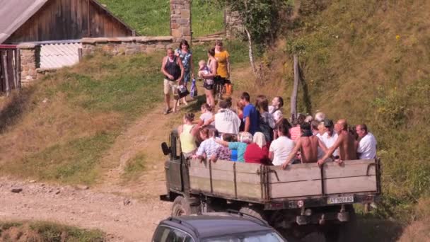 無許可のキャリッジの背景。トラックで輸送する人々のグループ。車のバスケットにたくさんの人が乗っている。人を運ぶローリー車。村人たちはお祝いに行く。村のお祝い. — ストック動画