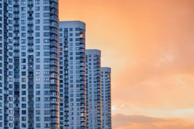 Balkonlu modern ve lüks bir bina. Apartman. Gün batımında gökdelenler. Kentsel soyut arka plan, modern cam cephe detay, ofis iş binası