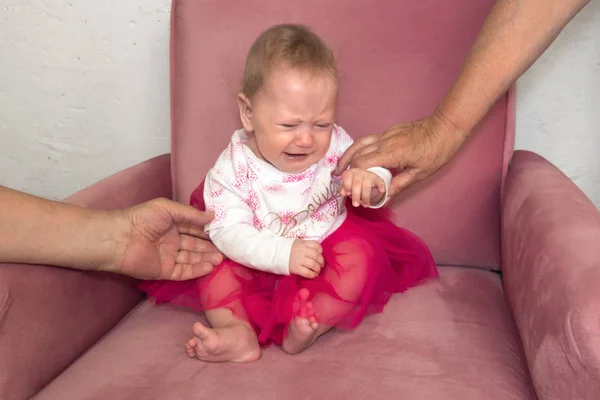 Gråtande småbarn. Barn hysteriker. Negativa känslor av barn, småbarn. Baby flicka sitter i stolen i rosa klänning. Negativa mänskliga känslor, ansiktsuttryck närbild — Stockfoto