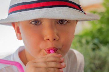 Dışarıda içiyor. Çocuklar için yaz içkileri. Doğal içecekler. Mutluluk kavramı. Seyahat konsepti. Yeşil turizm. Genç turist kokteyli içiyor. Kafede küçük bir çocuk. Yeni içkit