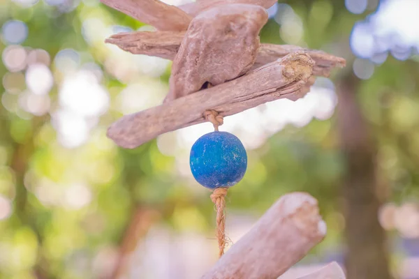 Wooden fish simbol. Wooden fish hanging on the rope. Blue ball hanging on the rope. Ecological wooden toys. Wind toys. Eco toys.