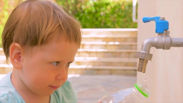 Fondo de jardín de infantes privado. Problemas de agua en la tierra. Preescolar jugando en el patio trasero en el verano. Llenar la botella de plástico con agua. Concepto Montessori. Falta de agua. agua dulce insuficiente — Vídeos de Stock