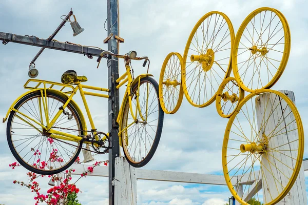 Fahrradkonzept. gelbes Fahrrad und verschiedene Formen von Rädern hängen an Stange mit Straßendesign-Element Außenfokus auf Retro-Vintage-Stil Fahrrad hängen fest an Stange keine Menschen Fahrrad Felge — Stockfoto