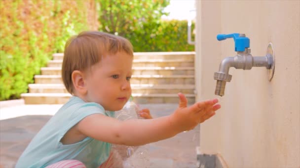 Anaokulu geçmişi. Pediatri kavramı. Bebek dünyayı keşfediyor. Bebeklerin elinde akan saf su. Dokunsal beceriler geliştirmek. Çocuğun uyumlu gelişimi. Bebekler için su terapisi çocuklar — Stok video