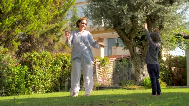 Alegre abuela divirtiéndose con nieto al aire libre. Niño divirtiéndose mientras visita a la abuela. Concepto de estilo de vida saludable. Concepto de infancia feliz . — Vídeos de Stock