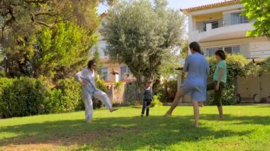 Bahçede yeşil çimüzerinde egzersiz yaparken üç nesil eğleniyor. Yetişkinler ve çocuklar sağlıklarını önemserler. Denize yakın villada yoga fitness egzersizleri yapmak