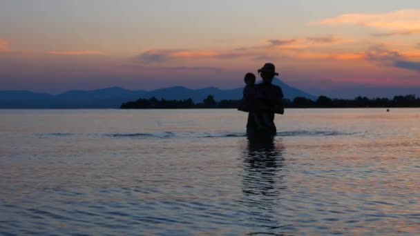 父亲带着孩子从海水中出去。带着孩子旅行。带孩子放暑假。孩子与父亲在海景背景。幸福的家庭理念。快乐的童年回旋. — 图库视频影像