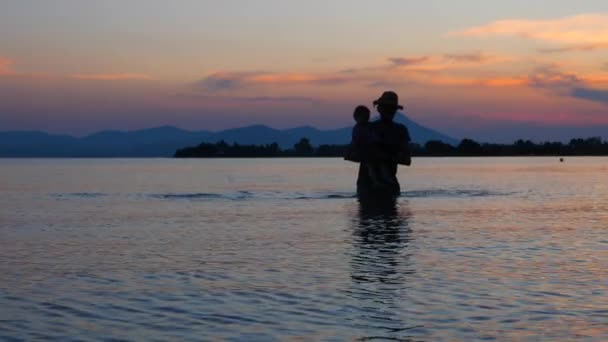 Πατέρας με παιδί που βγαίνει από το θαλασσινό νερό. Ταξιδεύοντας με παιδιά. Καλοκαιρινές διακοπές με παιδί. Παιδί με πατέρα στο τοπίο της θαλασσοφύσεως. Ευτυχισμένη οικογενειακή ιδέα. Καλή παιδική ηλικία πίσω. — Αρχείο Βίντεο