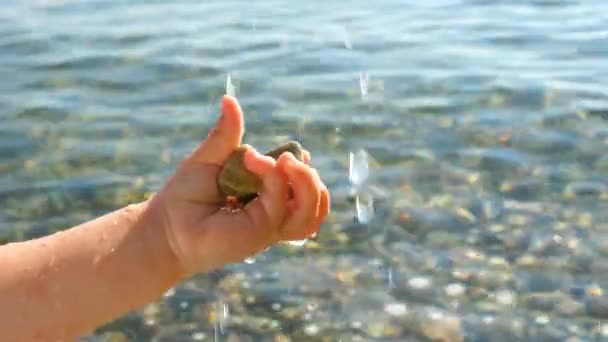 Babys mano cattura gocce d'acqua su sfondo paesaggio marino. Mano dei bambini che giocano con l'acqua. Concettuale Bambini sani. Concetto di viaggio. Sfondo felice infanzia. Bambini e natura — Video Stock