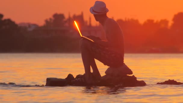 Hombre usando el ordenador portátil al aire libre, concepto de turista que trabaja en el ordenador portátil en el océano tropical exótico. Trabajo remoto en cualquier lugar. Tecnología y viajes. Trabajando al aire libre. Concepto freelancer. vista lateral — Vídeos de Stock