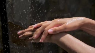 Elleri nemle zenginleştirir. Kadın Ellerine Damla Su Damlası. Büyüleyici Gösteri. Yaşam kaynağı olarak su. Kadın ellerine su damlaları,