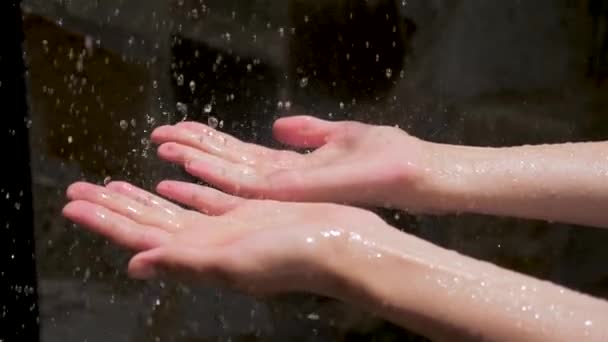 Gotas de gota de agua en las manos de las mujeres. Espectáculo encantador. El agua como fuente de vida. Gotas de agua en las manos de las mujeres , — Vídeo de stock