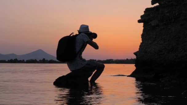 Művész figyelembe fotó állományok. Fiatal hím fényképész bevétel legjobb fénykép közben naplemente. Fotós utazik, és úgy képek. Képet és videót a készletek utazók