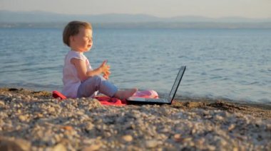 Deniz kıyısında defterli oturan küçük kız. İş ve tatili birleştiren yeni nesil insanlar. Yaratıcılık ve okul eğitimi. Eğitimde evrim ve devrim. Başarılı serbest fikir