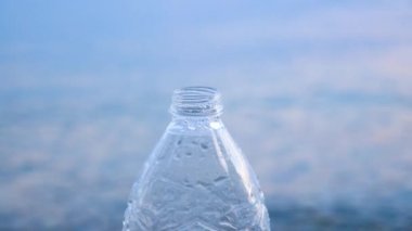 İçecek su arka plan. Arka planda su sıçramaları ve deniz suyu ile şişe. Davranış değişikliği için sosyal sanat. Maden suyu arka planı. Yeryüzünde içme suyu eksikliği