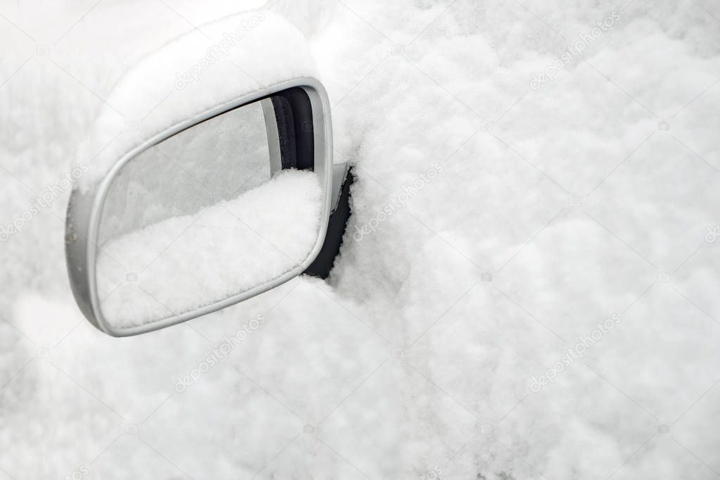 Car covered with snow. Car mirror sticking out of the snow. Winter season snow. Weather forecast. Early winter. Cold weather coming soon. Temperature below zero. Background, concept, idea