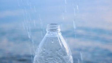 Güvenli su. Hijyen ve temizlik geçmişi. Deniz manzaralı şişeye su damlaları dökülüyor. Su ve tuzlu su iç. İnsan sağlığı ve içme suyu