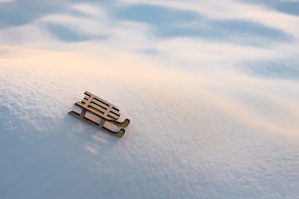 Έλκηθρο στο χιόνι για ευχετήρια κάρτα. Ξύλινο έλκηθρο σε λευκό χιόνι. Το παιχνίδι του έλκηθρου στο λόφο του χιονιού. Αντιγραφή χώρου. Ευχετήρια κάρτα για τις χειμερινές διακοπές. Σύμβολο του νέου έτους. Ευχετήρια κάρτα, φυλλάδιο. Ιστορικό χιονιού — Φωτογραφία Αρχείου