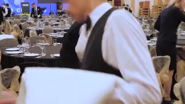 Kellner decken den Tisch in einem Restaurant, bevor die Kunden kommen, und verwenden feines Besteck und Gläser. Konzept: Catering, Design, romantische Abendessen. luxuriöse Catering-Hintergrund. Festidee — Stockvideo