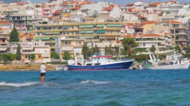 Turistik şehir. Seyahat konsepti. Şehir ve deniz manzarası güzel bir su renginde. Tekneden görüntü. Arkasında binalar olan bir gemi.