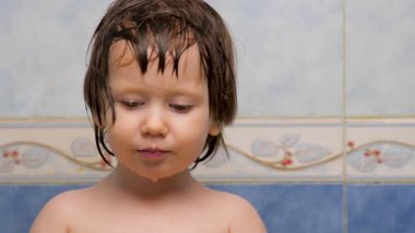 Yüz ifadesi konsepti. Kız kameraya bakıyor. Banyo yaptıktan sonra ıslak bir cilt. Pediatri konsepti. Islak saçlı küçük kızın bilge gözleri. Yüz ifadesi. Olumlu duygular. Tarafsız duygular