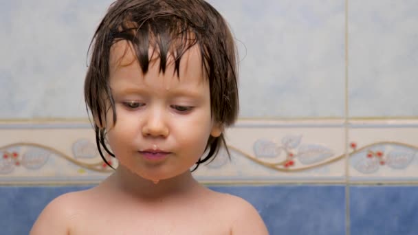 Yüz ifadesi konsepti. Kız kameraya bakıyor. Banyo yaptıktan sonra ıslak bir cilt. Pediatri konsepti. Islak saçlı küçük kızın bilge gözleri. Yüz ifadesi. Olumlu duygular. Tarafsız duygular — Stok video