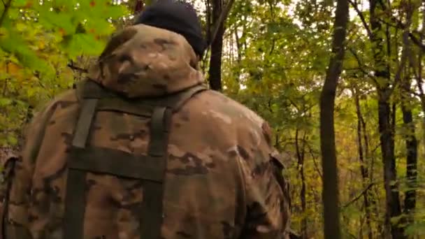 A group of masked military soldiers moving through the forest. Combat training. Armed soldiers performing a combat mission. Training practice in army. Military operation. Military intelligence — Stock Video