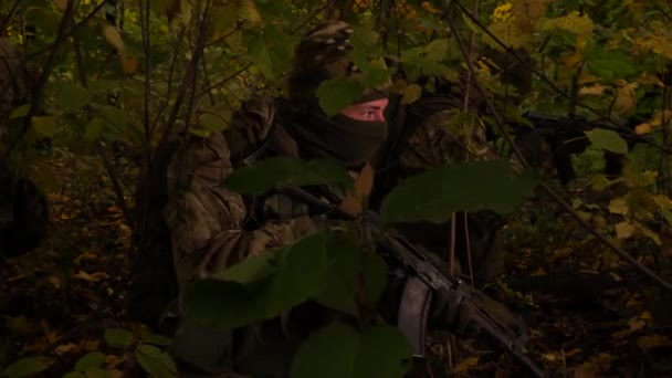 Maskierte Kommandos im Wald. Ein Soldat mit Gewehr beobachtet genau. Spezialeinheiten verstecken sich in einem Hinterhalt, bereit zum Angriff. — Stockvideo