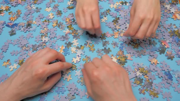 Assembling jigsaw puzzle. Hand matching jigsaw halves. Leisure activity. Achieving step by step Love concept. Engaging in successful work finding business solution, corporate unity — Stock Video