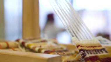 Arkaplanda zanaatkar kadın var. El yapımı arka plan. İplikler teller gibi gerilmiş..