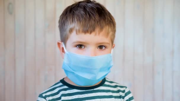 Портрет ребенка в защитной маске в общественном месте во время вспышки коронавируса и гриппа. Ковид-19, вспышка коронавируса. Следуя правилам защиты от ковида-19, коронавируса, вируса — стоковое видео