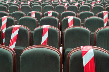 Sinemada, tiyatroda ve konferans salonunda kurdeleyle ayrılmış bir sandalyeye oturmam gerekiyor. Halka açık yerlerde güvenli bir sosyal mesafeyi korumak, insanların toplanması, etkinlikler. Koltuklarda uyarı işareti