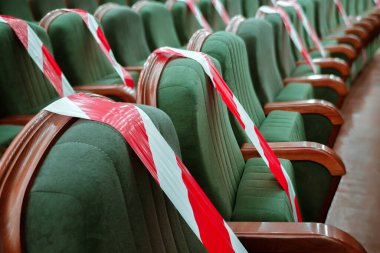 Sinema, tiyatro, konser salonu ve uyarı etiketli boş koltukların arka planı. Konferans, opera, tiyatro performansı. Coronavirus sırasında çalışmak, sosyal mesafeye bağlı kalmak