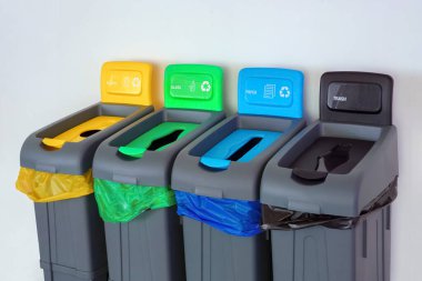 Dışarıda dört plastik atık kutusu var. Geri dönüşümlü malzemelerin toplanması için farklı renkte çöp kutuları. Farklı renkte çöp torbaları var. Çevre, ekoloji, kavramsal. Gezegen fikri kaydediliyor