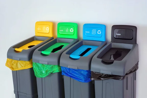 Dışarıda dört plastik atık kutusu var. Geri dönüşümlü malzemelerin toplanması için farklı renkte çöp kutuları. Farklı renkte çöp torbaları var. Çevre, ekoloji, kavramsal. Gezegen fikri kaydediliyor