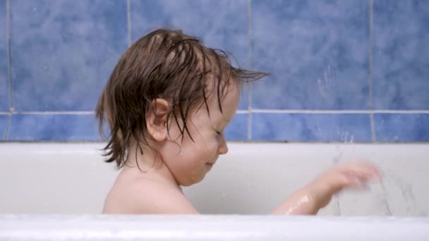 Atraente menina de 2-3 anos toma banho. Cabelo molhado. Bonita criança loira. Menina bonita na casa de banho. Emoções positivas. Conceito de pediatria. Felicidade nos olhos das crianças Entretenimento, lazer — Vídeo de Stock