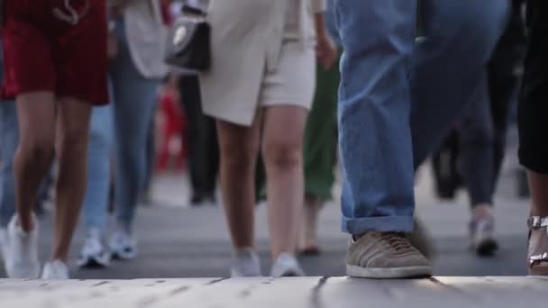 Massor av folk som går på gatan. Närbild av Crowd feet. Skjuten av trångt folk som går på gatan. Stadspubliken. Många ben går längs trottoaren. — Stockvideo